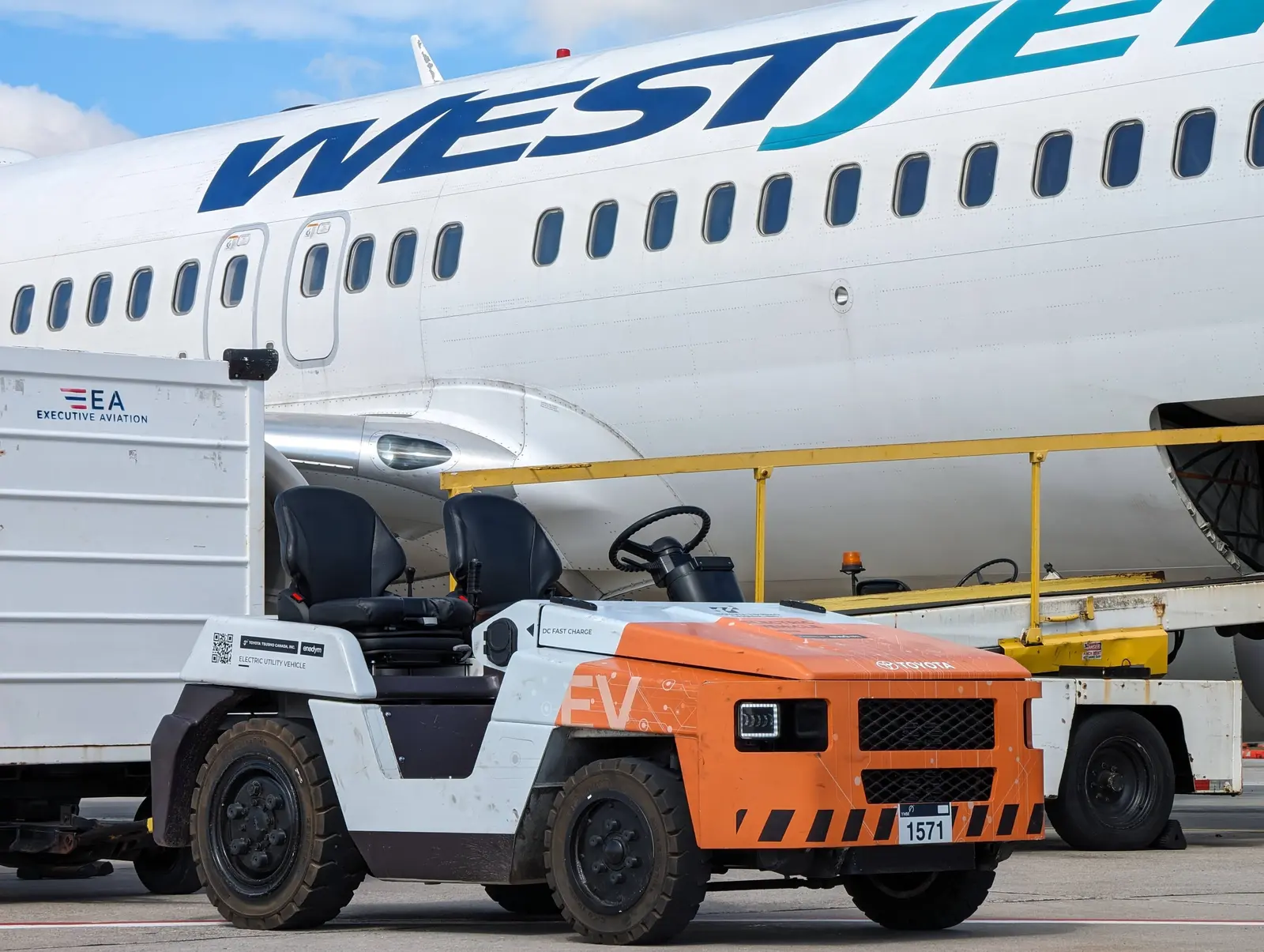 Enedym-powered electric utility tractor working a WestJet aircraft on the apron
